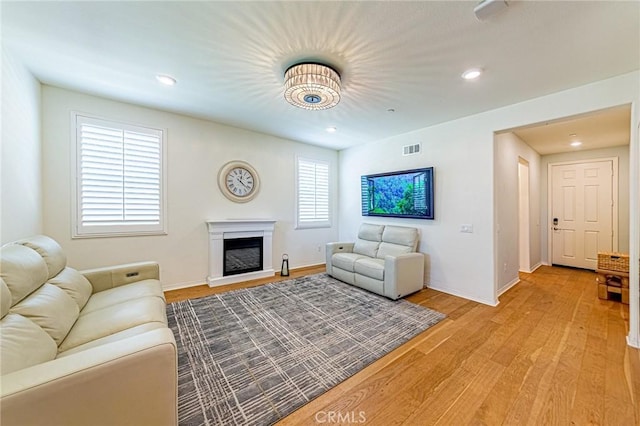 24207 Via Perla, Valencia, CA 91354 - living area featuring light wood finished floors, a glass covered fireplace, baseboards, and recessed lighting