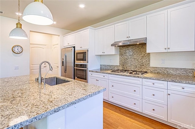 24207 Via Perla, Valencia, CA 91354 - kitchen featuring stainless steel appliances, under cabinet range hood, a sink, and white cabinetry