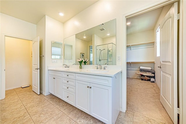 24207 Via Perla, Valencia, CA 91354 - full bathroom featuring double vanity, a stall shower, tile patterned flooring, a walk in closet, and baseboards