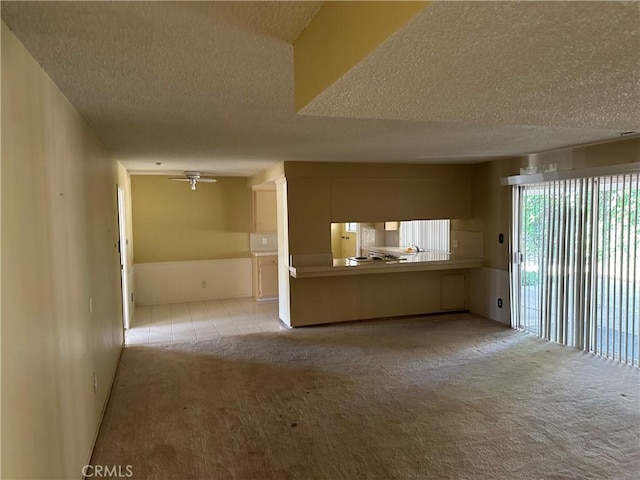 2915 El Camino Real, Merced, CA 95340 - unfurnished living room with a textured ceiling, light carpet, ceiling fan, and light tile patterned flooring