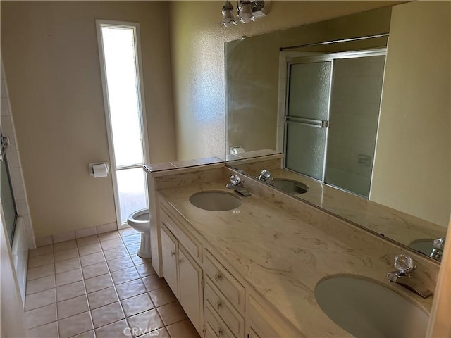 2915 El Camino Real, Merced, CA 95340 - full bathroom with toilet, double vanity, tile patterned floors, and bath / shower combo with glass door