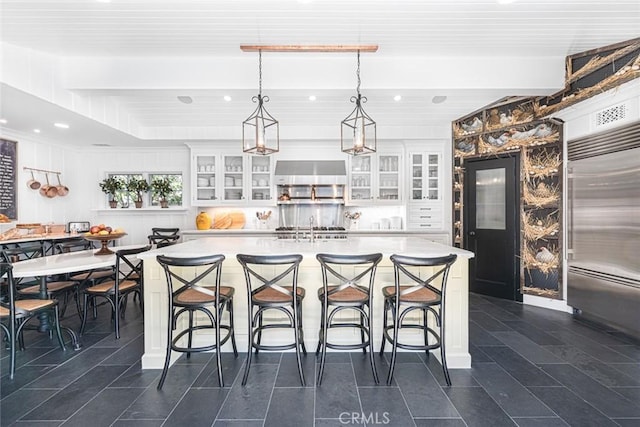105 Via Waziers, Newport Beach, CA 92663 - kitchen with built in fridge, white cabinets, light countertops, glass insert cabinets, and recessed lighting
