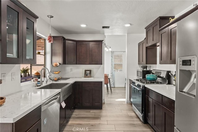 12063 Ocotillo Dr, Fontana, CA 92337 - kitchen featuring stainless steel appliances, dark brown cabinetry, light wood-type flooring, a sink, and recessed lighting