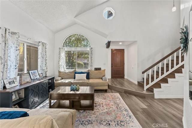 12063 Ocotillo Dr, Fontana, CA 92337 - living area featuring wood finished floors, stairway, baseboards, a textured ceiling, and high vaulted ceiling