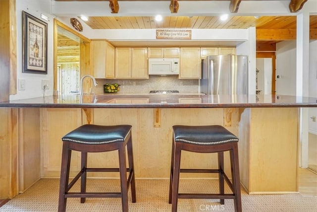 1954 Nob Hill Dr, Running Springs, CA 92382 - kitchen with freestanding refrigerator, white microwave, wood ceiling with exposed beams, light brown cabinetry, and a breakfast bar