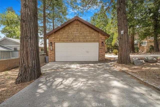 1954 Nob Hill Dr, Running Springs, CA 92382 - view of front of house featuring a garage, driveway, stone siding, and an outbuilding