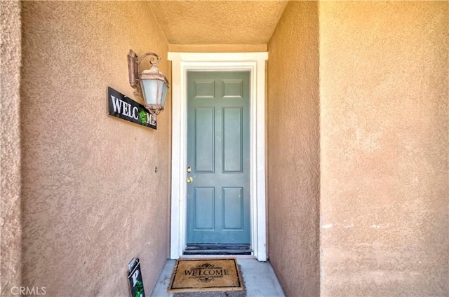 6810 Evans St, Palmdale, CA 93552 - doorway to property featuring stucco siding