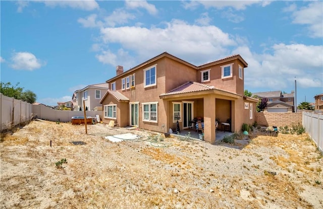 6810 Evans St, Palmdale, CA 93552 - back of property featuring stucco siding, a tiled roof, a fenced backyard, a patio, and a chimney
