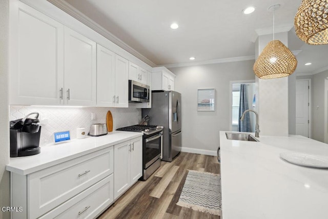 1503 Windshore Way, Oxnard, CA 93035 - kitchen with appliances with stainless steel finishes, a sink, ornamental molding, white cabinets, and wood finished floors