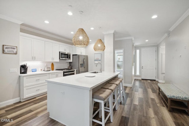 1503 Windshore Way, Oxnard, CA 93035 - kitchen featuring appliances with stainless steel finishes, a sink, a breakfast bar, crown molding, and white cabinets