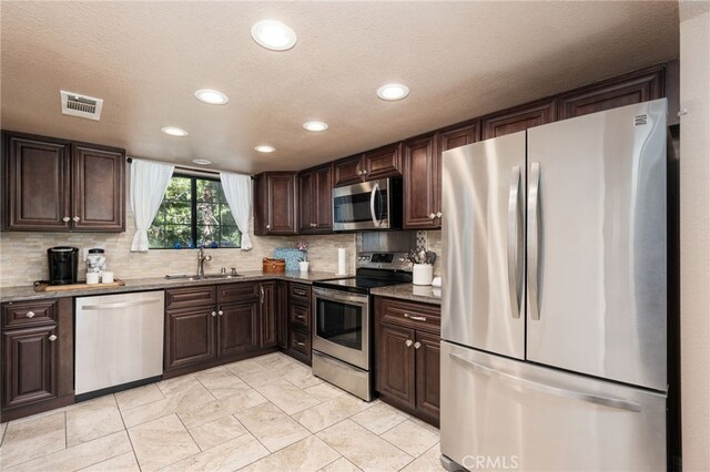 40603 Saddleback Rd, Bass Lake, CA 93604 - kitchen featuring stainless steel appliances, a sink, dark brown cabinets, recessed lighting, and backsplash