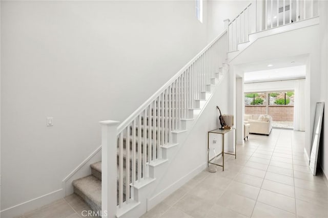 106 Bright Star, Irvine, CA 92618 - staircase with baseboards, tile patterned flooring, and a high ceiling