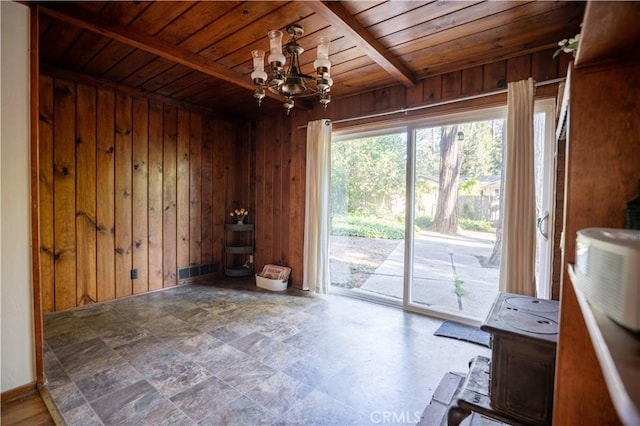10655 Banner Lava Cap Rd, Nevada City, CA 95959 - unfurnished living room featuring wooden ceiling with exposed beams, a chandelier, wood walls, and stone finish flooring