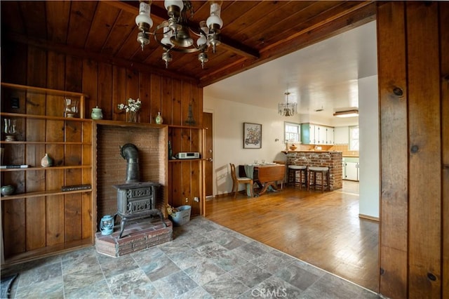 10655 Banner Lava Cap Rd, Nevada City, CA 95959 - living area with a chandelier, wood ceiling, a wood stove, wood walls, and stone finish floors