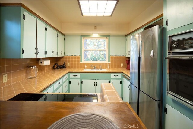 10655 Banner Lava Cap Rd, Nevada City, CA 95959 - kitchen featuring black appliances, a sink, tasteful backsplash, and tile counters