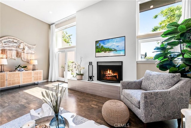 18743 Club Ln, Huntington Beach, CA 92648 - living room featuring a high ceiling, a lit fireplace, healthy amount of natural light, and wood finished floors