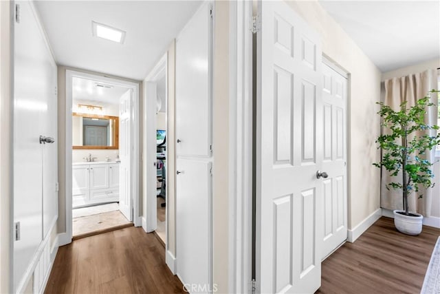 18743 Club Ln, Huntington Beach, CA 92648 - corridor featuring dark wood-style floors, baseboards, and a sink
