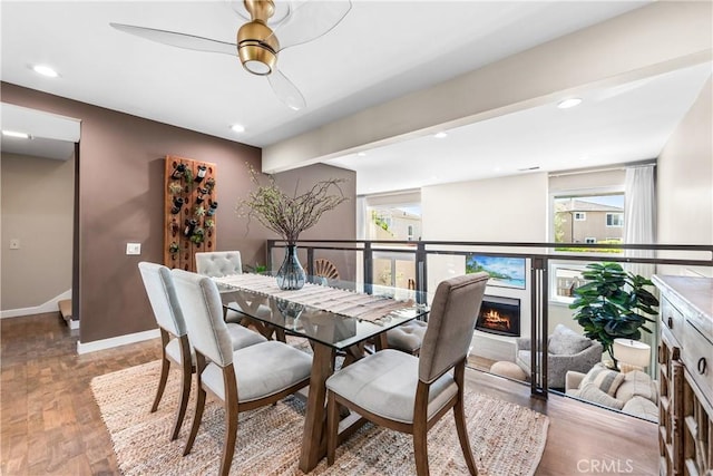 18743 Club Ln, Huntington Beach, CA 92648 - dining area featuring light wood finished floors, ceiling fan, baseboards, recessed lighting, and a warm lit fireplace