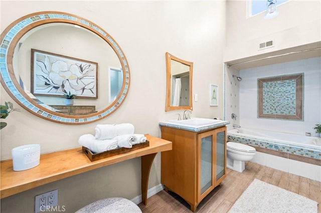18743 Club Ln, Huntington Beach, CA 92648 - bathroom featuring toilet, wood finished floors, tiled shower / bath combo, and vanity