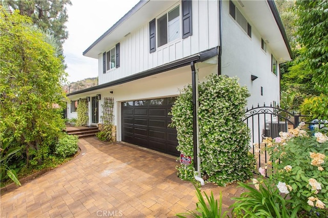 14879 Jadestone Dr, Sherman Oaks, CA 91403 - view of front facade featuring a garage, board and batten siding, and stucco siding