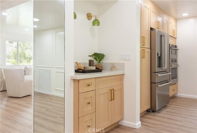 14879 Jadestone Dr, Sherman Oaks, CA 91403 - kitchen featuring appliances with stainless steel finishes, light brown cabinetry, light wood-style floors, light countertops, and baseboards