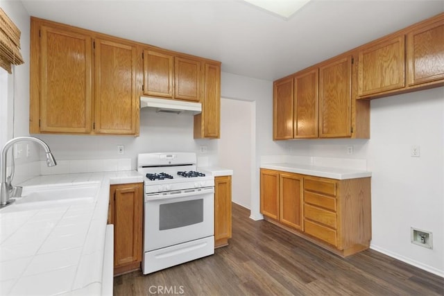 28265 Valombrosa Dr, Menifee, CA 92584 - kitchen featuring white range with gas stovetop, under cabinet range hood, a sink, tile counters, and dark wood-style flooring