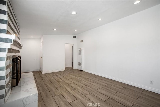 44128 Stanridge Ave, Lancaster, CA 93535 - unfurnished living room featuring recessed lighting, a fireplace, baseboards, wood finished floors, and a heating unit