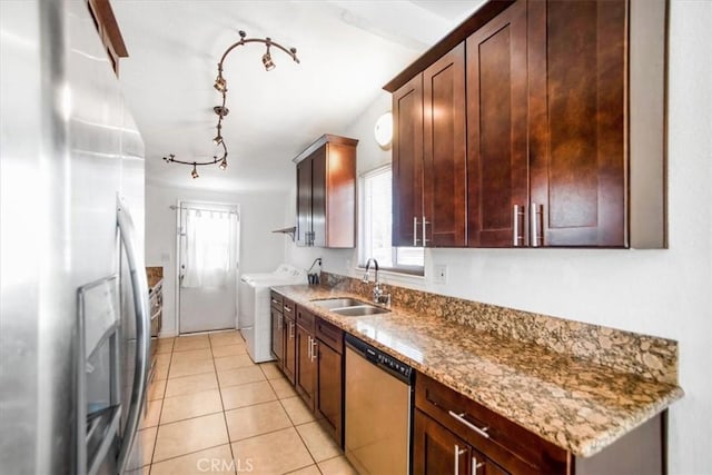 44128 Stanridge Ave, Lancaster, CA 93535 - kitchen featuring appliances with stainless steel finishes, a sink, washing machine and dryer, light tile patterned floors, and light stone counters