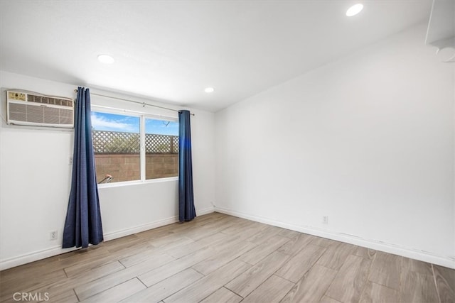 44128 Stanridge Ave, Lancaster, CA 93535 - spare room with light wood-style flooring, a wall mounted AC, recessed lighting, and baseboards