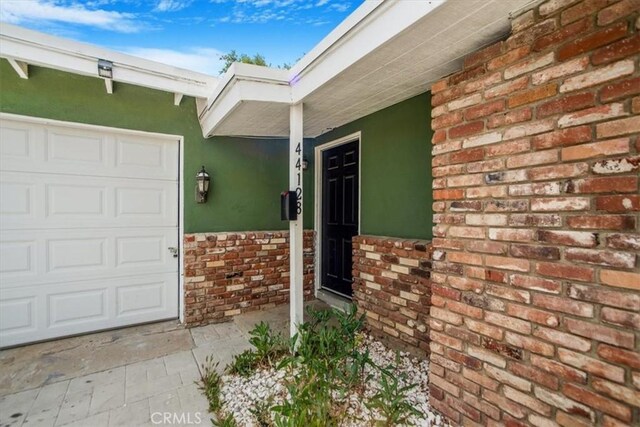 44128 Stanridge Ave, Lancaster, CA 93535 - doorway to property with stucco siding, brick siding, and an attached garage