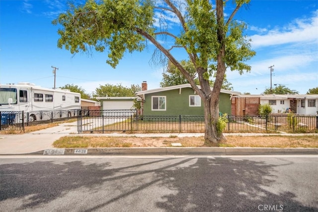 44128 Stanridge Ave, Lancaster, CA 93535 - view of front of home with a fenced front yard, a chimney, stucco siding, concrete driveway, and a garage