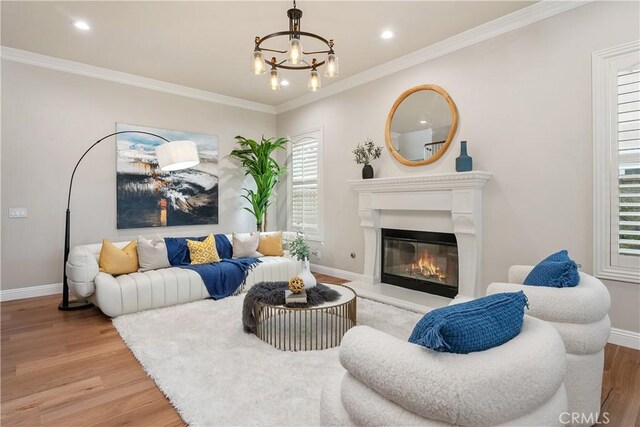18762 Pimlico, Yorba Linda, CA 92886 - living area featuring light wood-style floors, a chandelier, baseboards, a glass covered fireplace, and ornamental molding