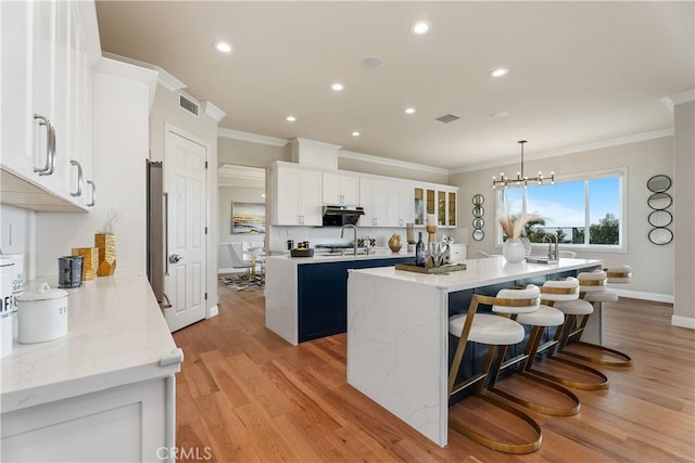 18762 Pimlico, Yorba Linda, CA 92886 - kitchen featuring a kitchen island with sink, ornamental molding, recessed lighting, light wood-type flooring, and white cabinets