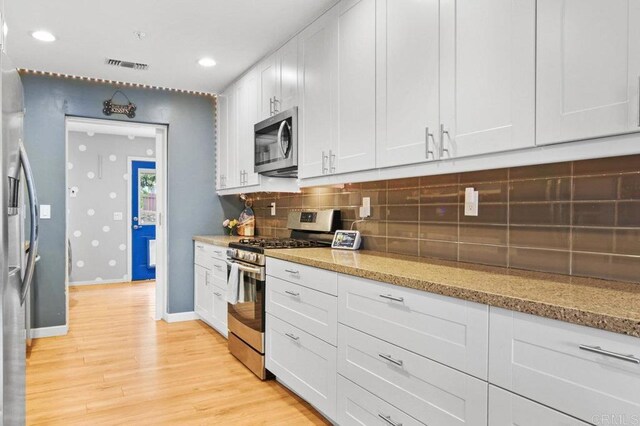 5441 Pennsylvania Ln, La Mesa, CA 91942 - kitchen featuring appliances with stainless steel finishes, baseboards, light wood-style flooring, backsplash, and light stone countertops