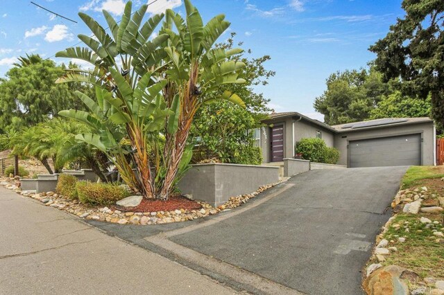 5441 Pennsylvania Ln, La Mesa, CA 91942 - view of front of property featuring driveway, solar panels, an attached garage, and stucco siding