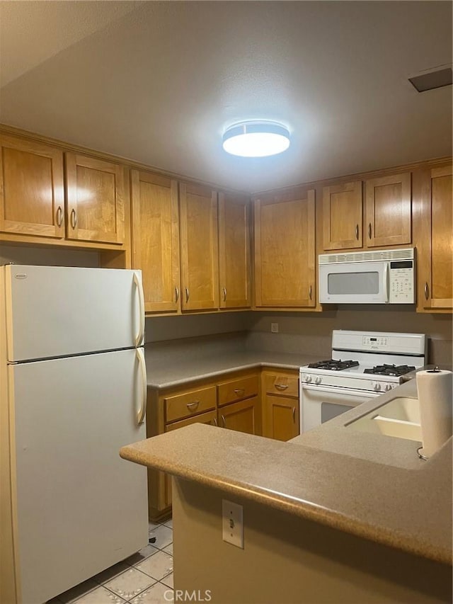 19167 Parkland St Unit 136, Yorba Linda, CA 92886 - kitchen featuring white appliances, light tile patterned floors, a sink, a peninsula, and brown cabinets