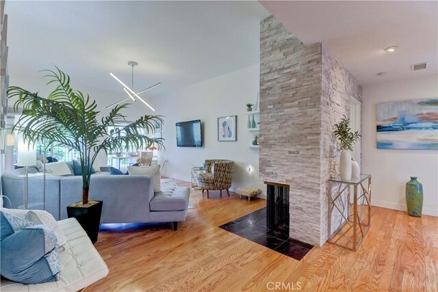 3521 Bahia Blanca W Unit C, Laguna Woods, CA 92637 - living area featuring wood finished floors, a stone fireplace, and baseboards