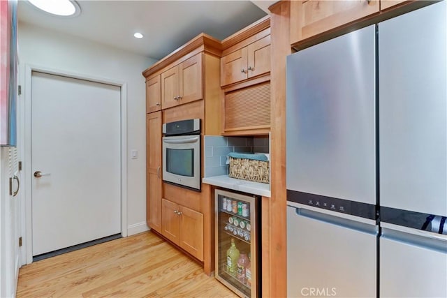 3521 Bahia Blanca W Unit C, Laguna Woods, CA 92637 - kitchen with beverage cooler, stainless steel appliances, light wood finished floors, decorative backsplash, and recessed lighting