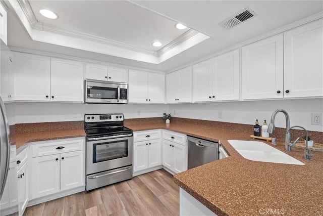 62 Wild Horse Loop Unit 29, Rancho Santa Margarita, CA 92688 - kitchen featuring appliances with stainless steel finishes, a raised ceiling, recessed lighting, crown molding, and white cabinets