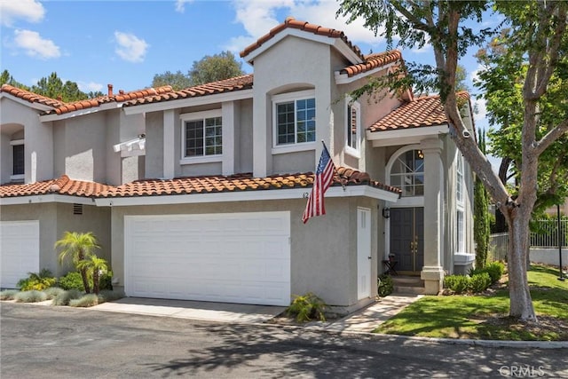 62 Wild Horse Loop Unit 29, Rancho Santa Margarita, CA 92688 - mediterranean / spanish house with a garage, a tiled roof, driveway, and stucco siding