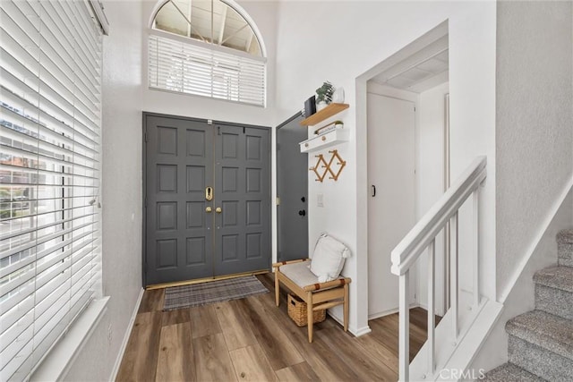 62 Wild Horse Loop Unit 29, Rancho Santa Margarita, CA 92688 - entrance foyer with wood finished floors, stairway, and a towering ceiling