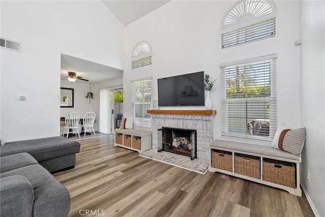 62 Wild Horse Loop Unit 29, Rancho Santa Margarita, CA 92688 - living area with ceiling fan, high vaulted ceiling, wood finished floors, and a brick fireplace