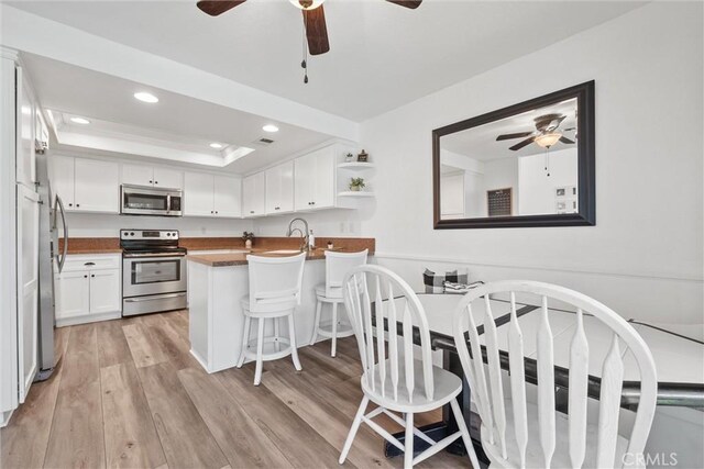 62 Wild Horse Loop Unit 29, Rancho Santa Margarita, CA 92688 - kitchen with stainless steel appliances, ceiling fan, light wood-style floors, white cabinets, and recessed lighting