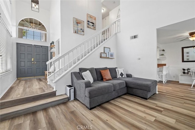 62 Wild Horse Loop Unit 29, Rancho Santa Margarita, CA 92688 - living room featuring a towering ceiling, stairway, wood finished floors, and healthy amount of natural light
