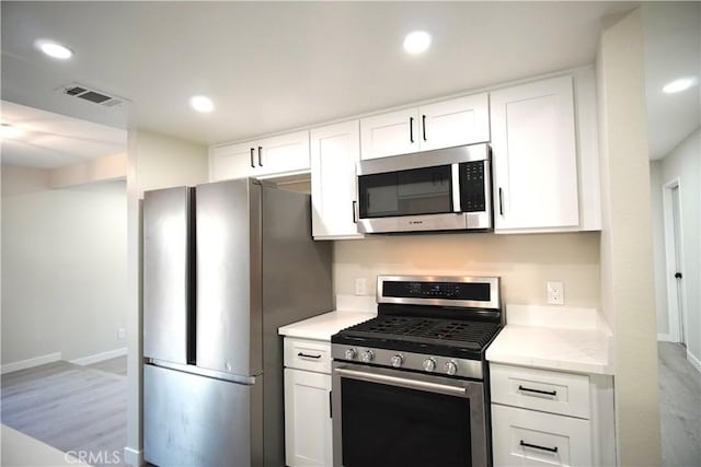 5187 Cedar St, Jurupa Valley, CA 92509 - kitchen with stainless steel appliances, white cabinets, light countertops, recessed lighting, and light wood-style floors