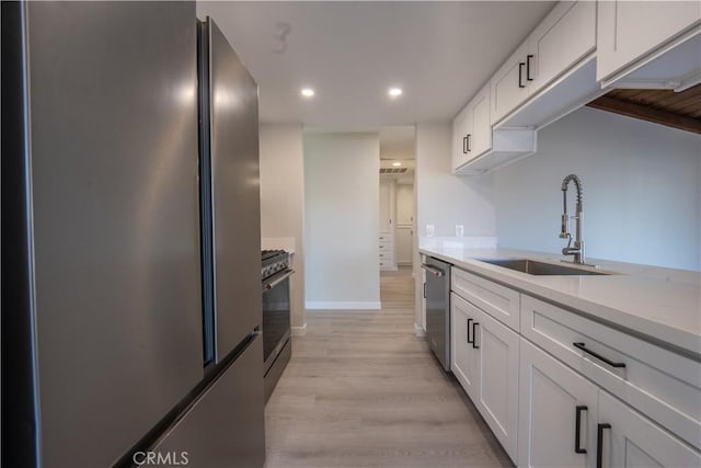 5187 Cedar St, Jurupa Valley, CA 92509 - kitchen featuring appliances with stainless steel finishes, white cabinets, light countertops, light wood-style flooring, and recessed lighting