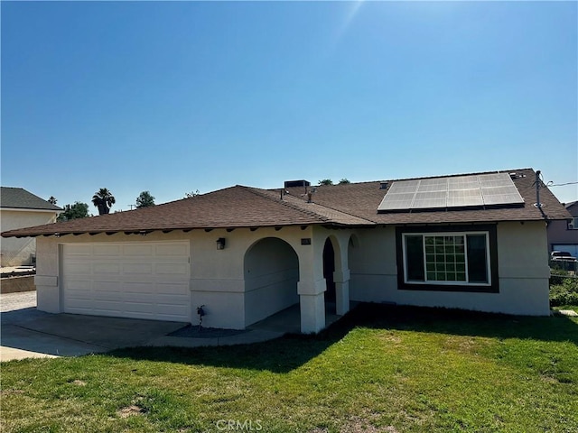 5187 Cedar St, Jurupa Valley, CA 92509 - view of front facade with roof mounted solar panels, an attached garage, a front yard, stucco siding, and roof with shingles