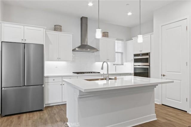660 Daniel Freeman Cir, Inglewood, CA 90301 - kitchen featuring appliances with stainless steel finishes, wall chimney range hood, a sink, decorative backsplash, and white cabinetry