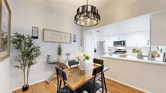 8535 Creekside Pl, Rancho Cucamonga, CA 91730 - dining area featuring light wood-style floors, baseboards, and a chandelier