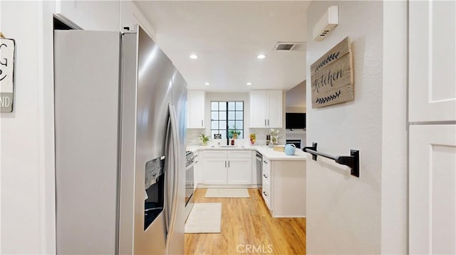8535 Creekside Pl, Rancho Cucamonga, CA 91730 - kitchen with stainless steel appliances, white cabinetry, light wood-style floors, light countertops, and recessed lighting